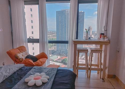 ein Kind, das in einem Stuhl vor einem Fenster schläft in der Unterkunft Casabay Suite Eastwood Staycation in Manila