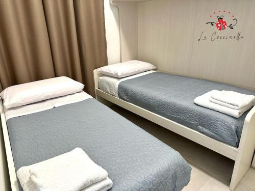 ein Zimmer mit 2 Betten und Handtüchern darauf in der Unterkunft La Coccinella in Graniti