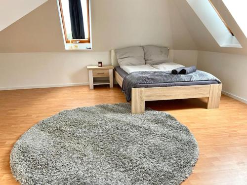 ein Schlafzimmer mit einem Bett und einem Teppich in einem Zimmer in der Unterkunft gemütliches Apartment Döhren in Hannover