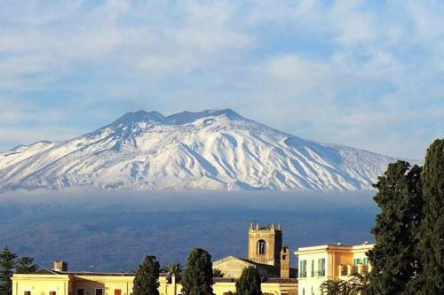 a snow covered mountain in the distance behind a building at La Coccinella in Graniti