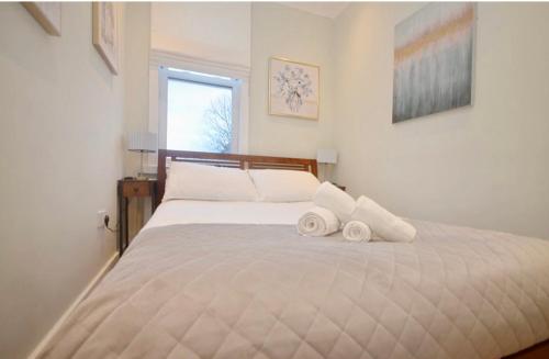 a bedroom with a bed with two towels on it at 2 Bedroom Flat London,Sleeps 6, Top Floor, Roof Terrace, Next to Brixton Underground Station in London