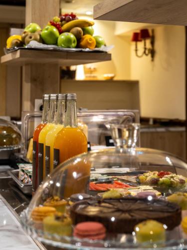 a counter with a tray of food and bottles of juice at Hotel Minerve in Paris