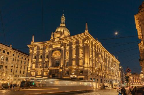 a large building at night with a street at Palazzo Cordusio, a Gran Melia Hotel in Milan