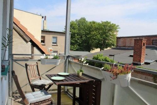 d'un balcon sur le toit avec une table et des chaises. dans l'établissement Am Mühlenbach - ABC270, à Wismar