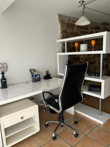 a white desk with a black chair in a room at JF - Apartments in Balingen