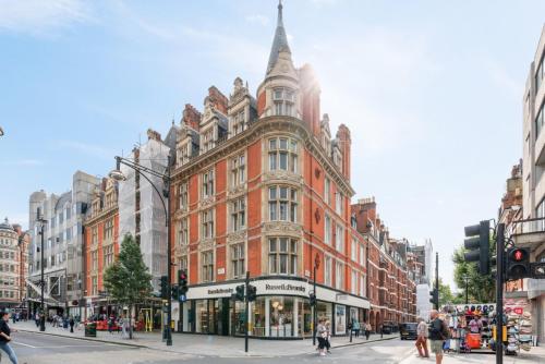 a large red brick building on a city street at Oxford Street Grandeur - Perfect for Large Groups in London