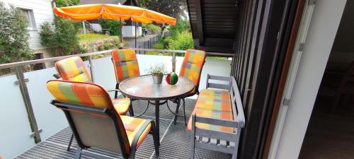 una mesa y sillas en un balcón con sombrilla en Ferienwohnung Familie Süttner, en Nagel