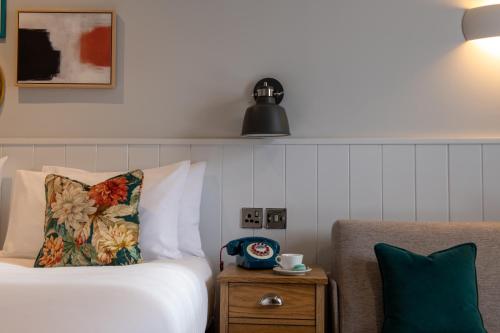 a hotel room with a bed and a nightstand with a pillow at Middletons in York