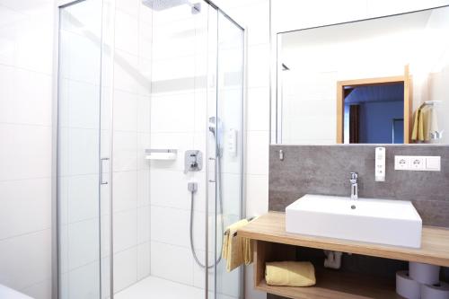 a bathroom with a sink and a shower at Landhotel Schellenberg in Überlingen