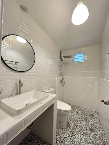 a bathroom with a sink and a toilet and a mirror at 3 bedroom & loft pool villa copacolanta in Ko Lanta