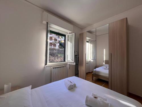 een slaapkamer met een wit bed en een raam bij Relax & Mare in Rapallo