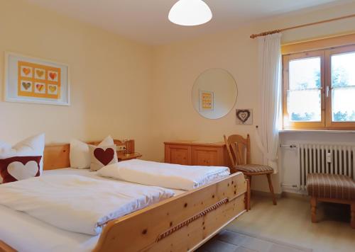 a bedroom with two beds and a desk and a window at Hörnerblick in Fischen