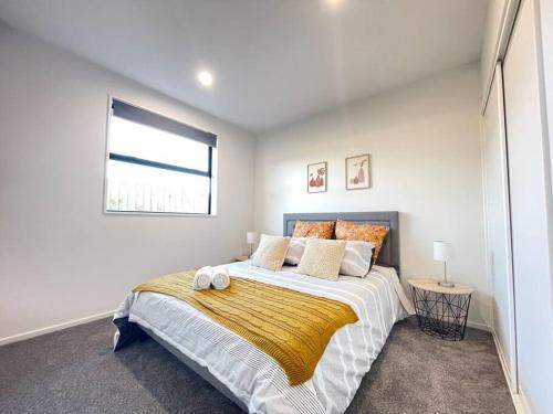 a bedroom with a large bed and a window at Luxury Brand New 4 Bedroom Family Retreat in Christchurch
