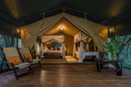 a tent with a bed and a woman in it at Soroi Mara Bush Camp in Masai Mara