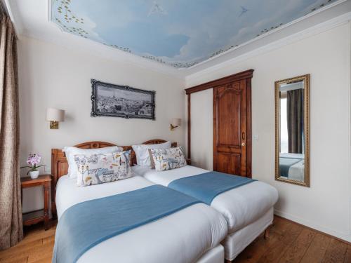 a bedroom with two beds and a window at Hotel Minerve in Paris