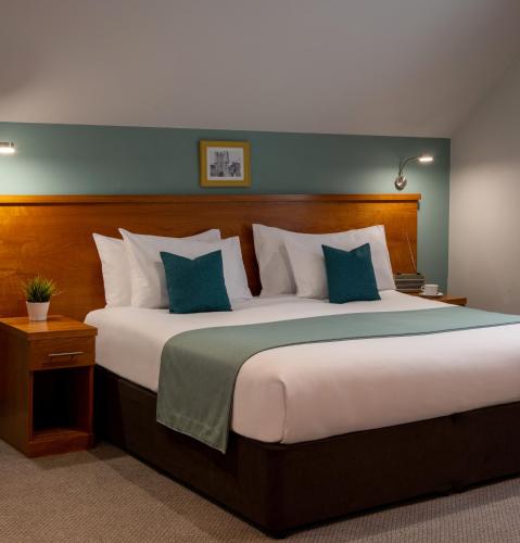 a bedroom with a large bed with blue and white pillows at Middletons in York