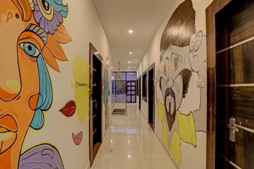 a hallway with paintings on the walls at OYO Madpackers Khajuraho in Khajurāho