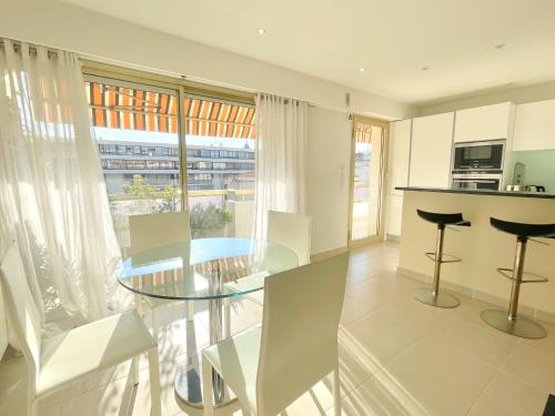 une cuisine et une salle à manger avec une table et des chaises en verre dans l'établissement PR Croisette, by Welcome to Cannes, à Cannes