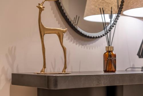 een bronzen giraffe op een tafel naast een spiegel bij Villa Come in Luxemburg
