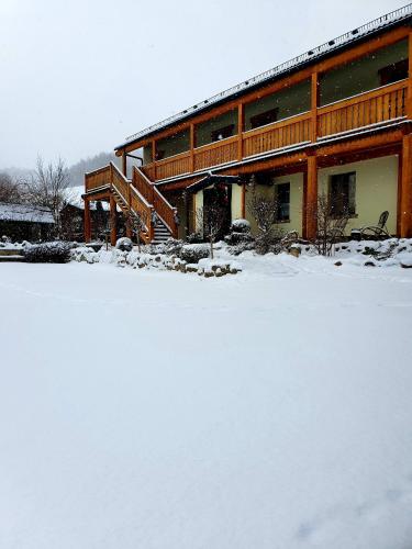 un patio cubierto de nieve frente a un edificio en Agroturystyka Natura, en Pilchowice