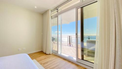 a living room with a large window with a view of the ocean at Sunset Views in Funchal