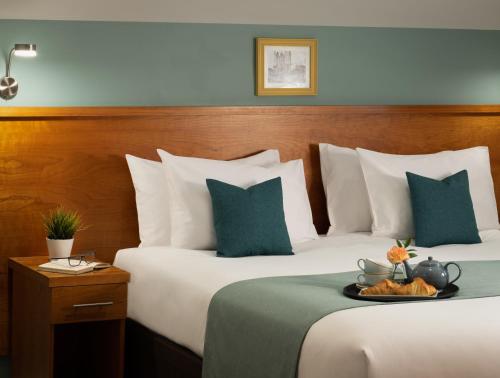 a hotel room with two beds with green and white pillows at Middletons in York