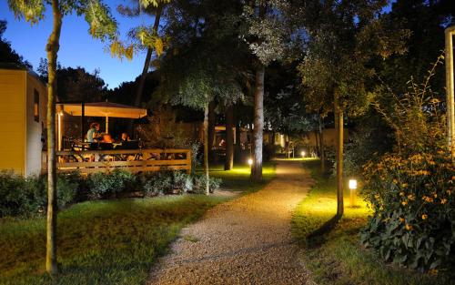 a garden at night with people sitting at a restaurant at Dei Fiori Camping Village in Cavallino-Treporti