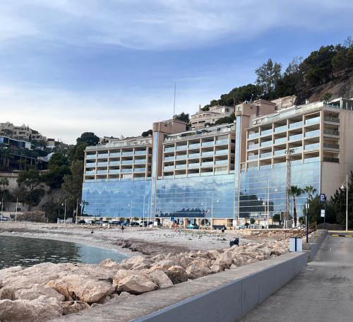 a large building on the beach next to the ocean at Apartamento en Altea con vistas al mar in Altea