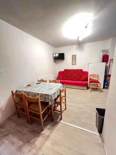 a living room with a table and a red couch at Ubytování Sýkora Apartments in Veľký Meder