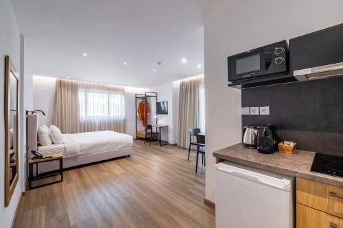 a hotel room with a bed and a kitchen at Pnoe Urban Living in Athens