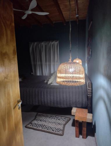 a bedroom with a bed with a fan and a chandelier at Pomancillo Ecolodge 