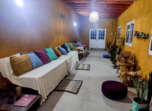 a living room with a long couch with colorful pillows at Pomancillo Ecolodge 