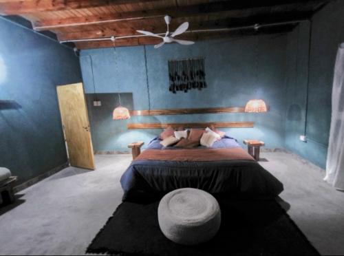 a bedroom with a large bed with a ceiling fan at Pomancillo Ecolodge 