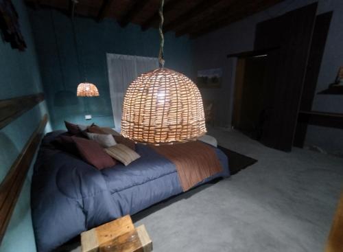 a bedroom with a blue bed and a chandelier at Pomancillo Ecolodge 