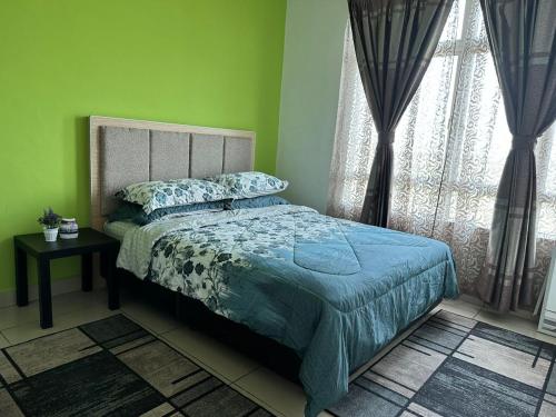 a bedroom with a bed and a green wall at Devianna Al Fateh Wakaf Che Yeh in Kota Bharu