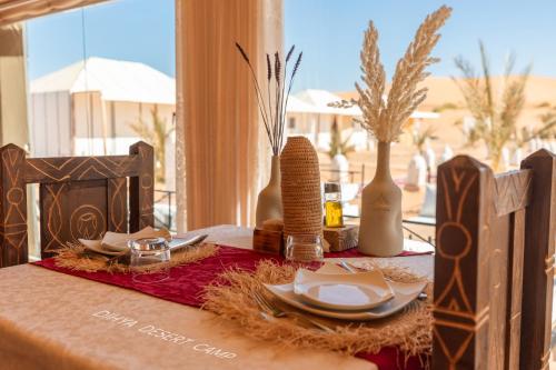 a table with plates and vases on a table at Dihya desert camp in Merzouga