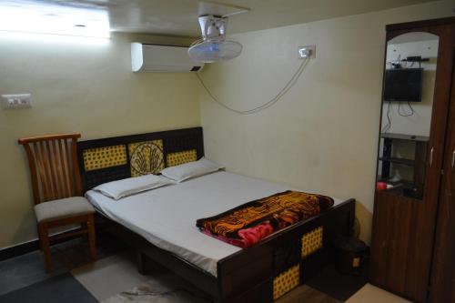 a small bedroom with a bed and a chair at Hotel Garden Residency By WB Inn in Bangalore
