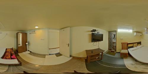 a room with a bathroom with a sink and a tv at Hotel Garden Residency By WB Inn in Bangalore