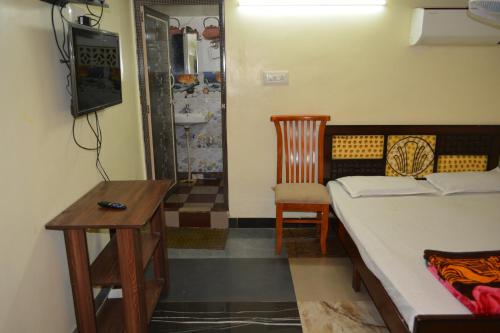 a bedroom with a bed and a table and a chair at Hotel Garden Residency By WB Inn in Bangalore