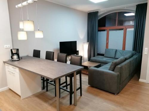 een keuken en een woonkamer met een tafel en een bank bij Cityflair Nähe Marktplatz - ABC328 in Wismar