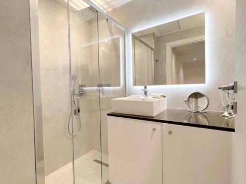 une salle de bain blanche avec un lavabo et une douche dans l'établissement Marema appartement, by Welcome to Cannes, à Cannes