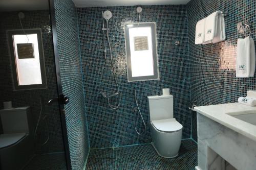 a bathroom with a shower and a toilet and a sink at Dibba Mountain Park Resort in Fujairah