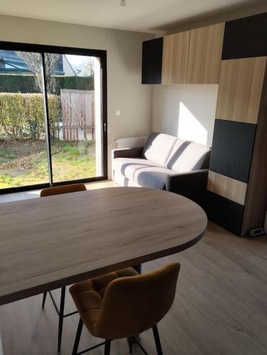 Cette chambre comprend une table, un lit et un canapé. dans l'établissement Studio tout neuf proche Rennes, à Saint-Grégoire