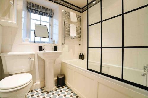 a bathroom with a toilet and a tub and a sink at Fabulous Folds Cottage in Curbar