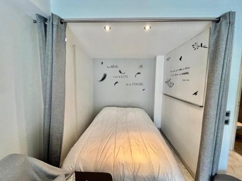 - un lit dans un dortoir avec des panneaux sur le mur dans l'établissement Jolies Lavandes, by Welcome to Cannes, à Cannes