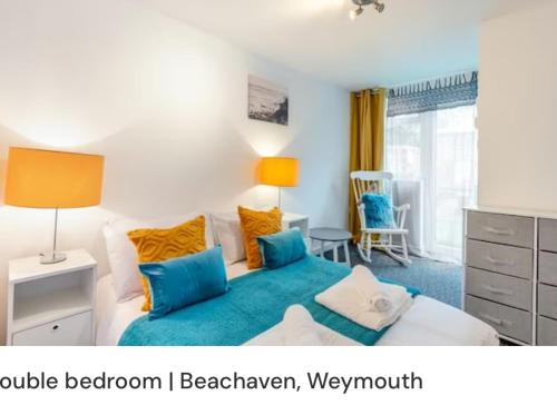 um quarto com uma cama com almofadas azuis e amarelas em Beachaven (7 Bedroom/5 Bathroom) em Weymouth