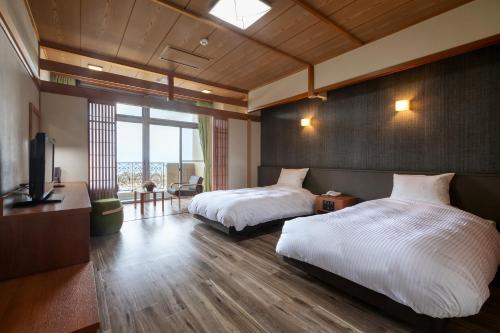 a hotel room with two beds and a television at Ocean Resort Nomon長崎 in Nomo