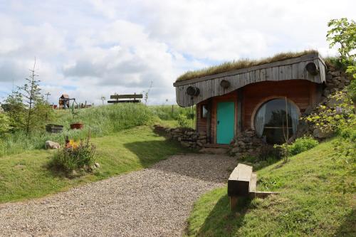 a small house with a grass roof on a hill at Shepherd's Loch Glamping in Turriff