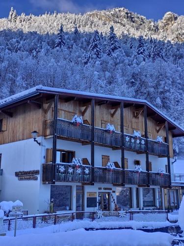 um edifício com uma varanda com árvores cobertas de neve em Les Chemins du Léman em Novel