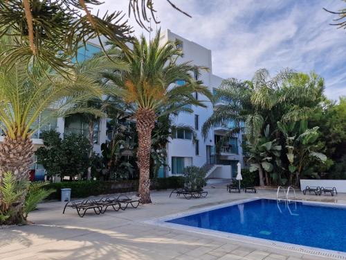 ein Resort mit einem Pool und Palmen in der Unterkunft Coralli Spa Resort Protaras Stylish 1 Bedroom apartment in Protaras
